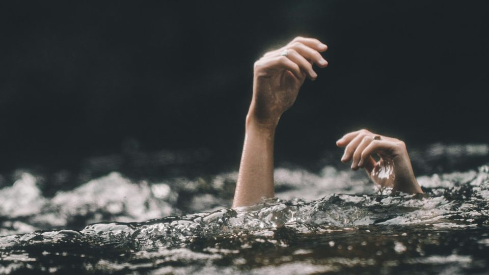 Personne qui se noie, fond sombre, mer agitée